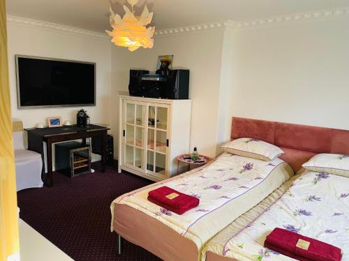ein Hotelzimmer mit 2 Betten und einem TV in der Unterkunft K&B Residence in Jarosław