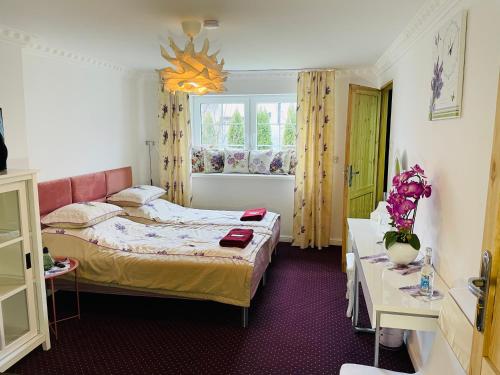 um pequeno quarto com uma cama e uma janela em K&B Residence em Jarosław