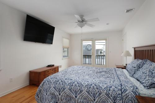 1 dormitorio con 1 cama y TV de pantalla plana en Seas The Day - Ortley Beach House, en Seaside Heights