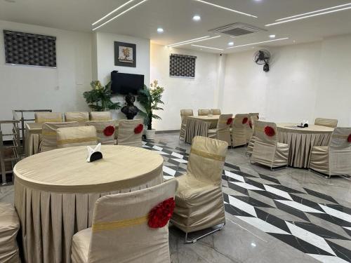 a waiting room with tables and chairs and a tv at Hotel The Heera Divine in Kānpur