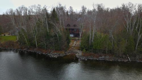 an aerial view of a house next to a body of water at Chalet des bouleaux in Nominingue