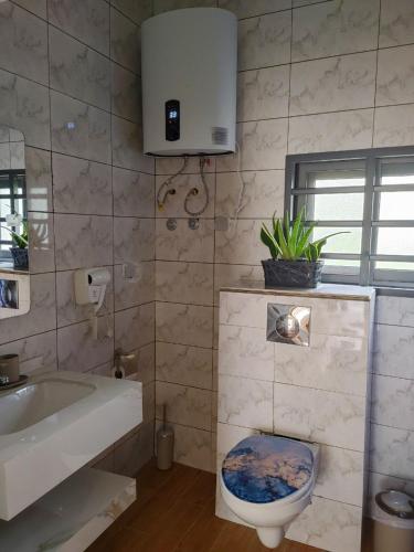 a bathroom with a toilet and a sink and a tub at LES 9 PLURIELLES - Studio 5 in Palimé
