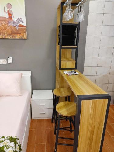 Kleines Zimmer mit einem Bett und einem Schreibtisch mit zwei Stühlen in der Unterkunft LES 9 PLURIELLES - Studio 5 in Palimé