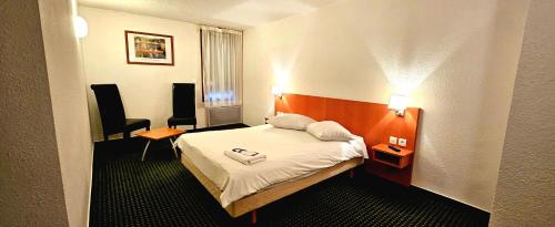 une chambre d'hôtel avec un lit et une chaise dans l'établissement Beddy-bye Hôtel, à Contrexéville