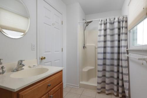 a bathroom with a sink and a shower with a mirror at Seas The Day - Ortley Beach House in Seaside Heights