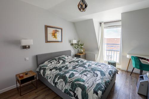 een slaapkamer met een bed en een raam bij Aux Berges du Rhône, Spacieux T3 Climatisé in Lyon