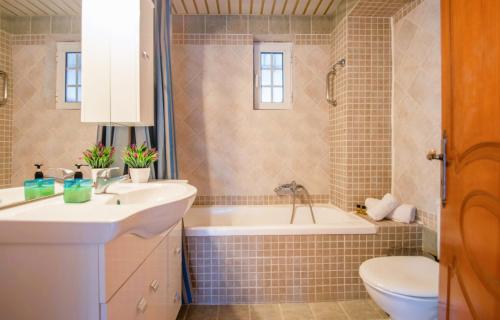 Zante Sun I - Getaway Villa! في مدينة زاكينثوس: حمام مع حوض وحوض استحمام ومرحاض