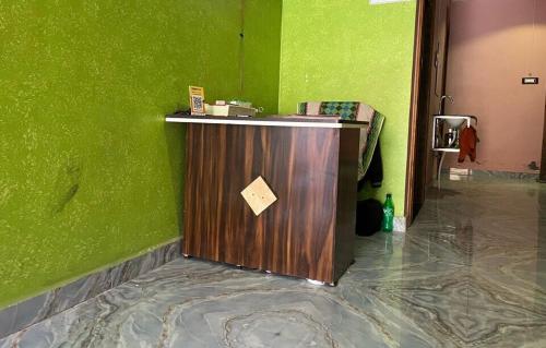 einen Tresen in einem grünen Raum mit einer grünen Wand in der Unterkunft OYO Fauji Villa in Kānpur