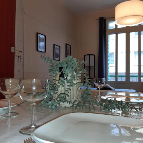 une table avec des verres à vin et une plante dessus dans l'établissement ML21 - Une vague de plaisir, à Mers-les-Bains