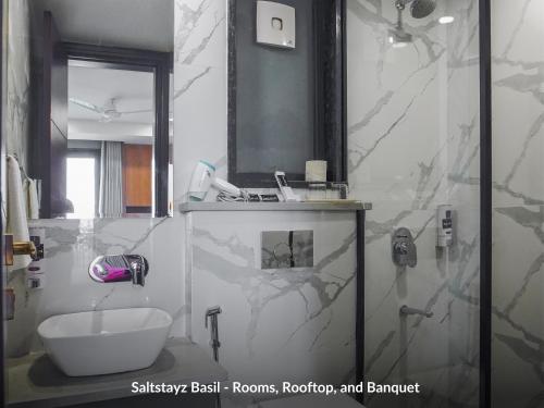 a bathroom with a sink and a mirror at Saltstayz Basil - Near Golf Course Road & Extension Road in Gurgaon