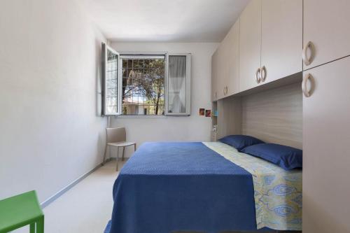 Un dormitorio con una cama azul y una ventana en Appartamento Paradise by BarbarHouse, en Santa Caterina di Nardò