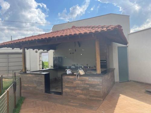 een buitenkeuken met een dak op een huis bij Pousada e Edícula in Jabuticabal