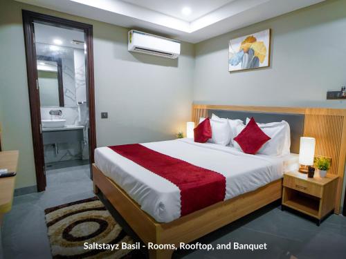 a bedroom with a large bed and a bathroom at Saltstayz Basil - Near Golf Course Road & Extension Road in Gurgaon