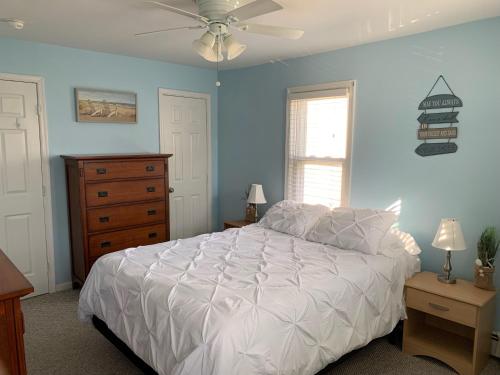 a bedroom with a white bed and a dresser at Bradley Beach Cozy Retreat in Bradley Beach