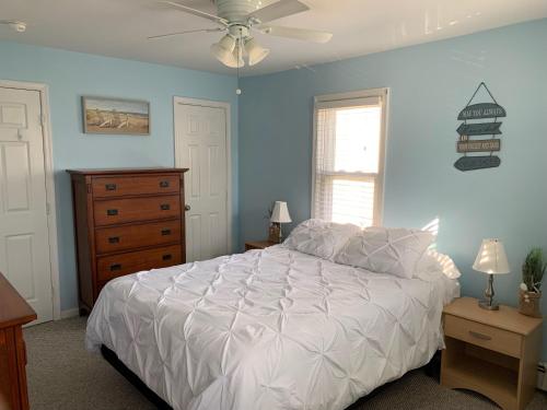 ein Schlafzimmer mit einem weißen Bett und einer Kommode in der Unterkunft Bradley Beach Cozy Retreat in Bradley Beach
