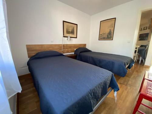 2 Betten in einem Zimmer mit blauer Bettwäsche in der Unterkunft 501 - Ap. Cant del Ocells in Palafrugell
