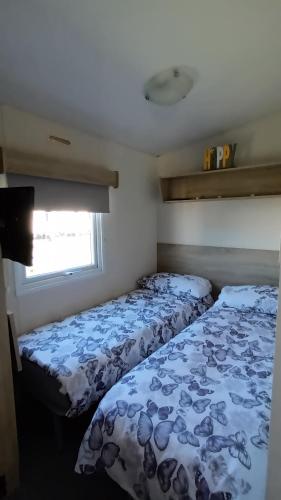 - 2 lits dans une petite chambre avec fenêtre dans l'établissement Serena, West Sands, Selsey, à Selsey
