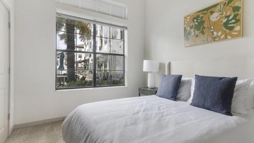 Habitación blanca con cama y ventana en Landing Modern Apartment with Amazing Amenities (ID1019X387) en Orlando
