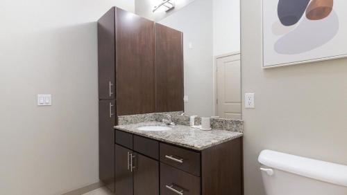 y baño con lavabo y aseo. en Landing Modern Apartment with Amazing Amenities (ID1019X387) en Orlando