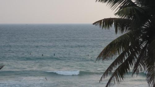 a view of the ocean with people in the water at Surf View Resort in Ahangama