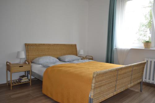 een slaapkamer met een bed met een gele deken en een raam bij Słoneczny Apartament Symi in Sopot