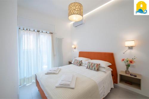 a white bedroom with a bed with towels on it at Casa Antalina in Agerola