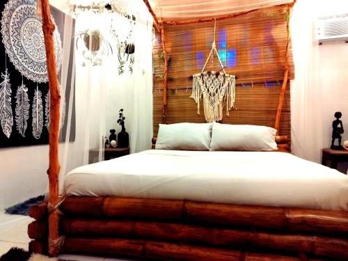 um quarto com uma cama e uma cabeceira em madeira em Umali Guesthouse em Magalang