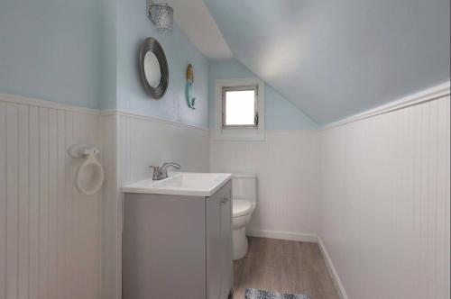 a white bathroom with a sink and a toilet at Island Time- beautifully renovated bay view home in Seaside Heights