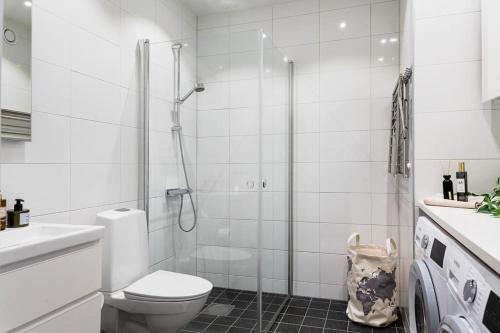 a white bathroom with a toilet and a shower at Modern Scandinavian Home in Stockholm in Stockholm