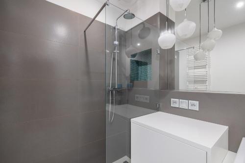 y baño con ducha, lavabo y espejo. en Duńska Chic Apartment, en Szczecin