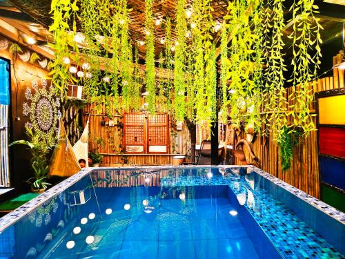 uma piscina com plantas penduradas no tecto em Umali Guesthouse em Magalang