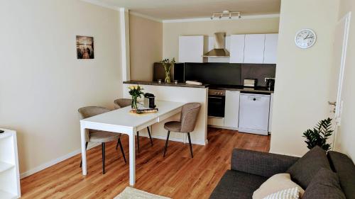 Il dispose d'une cuisine et d'un salon avec une table et des chaises blanches. dans l'établissement Schöne Wohnung Kerpen, à Kerpen
