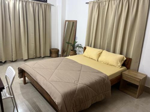 Schlafzimmer mit einem Bett und einem Fenster mit Vorhängen in der Unterkunft BKR homestay 2bhk in Itānagar