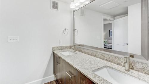 baño con 2 lavabos y espejo grande en Landing Modern Apartment with Amazing Amenities (ID4250X31), en Frisco