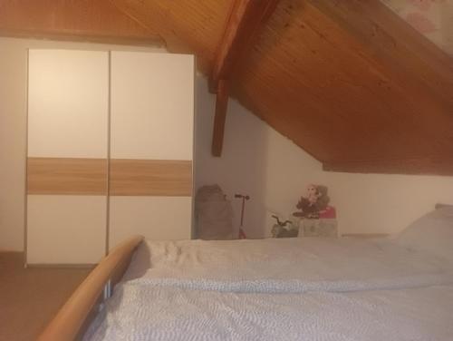a bedroom with a bed and a white cabinet at Ubytování Háj in Jindřichovice
