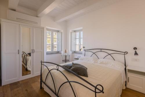 Dormitorio blanco con cama con marco de metal en Villa Margherita en Francavilla dʼEte