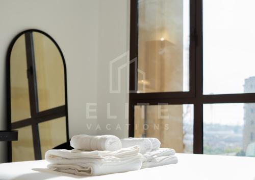 uma pilha de toalhas sentadas num balcão em frente a uma janela em Madinat Jumeirah Living 1 Bed Pool and Garden View em Dubai