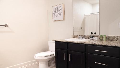 y baño con aseo blanco y lavamanos. en Landing Modern Apartment with Amazing Amenities (ID7274X30), en Baton Rouge