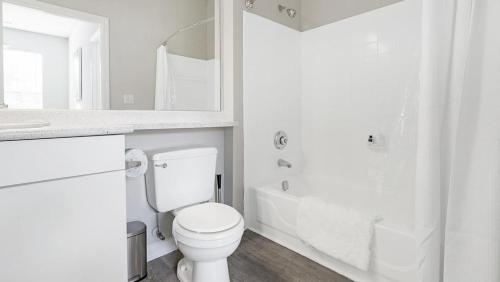 y baño blanco con aseo y ducha. en Landing Modern Apartment with Amazing Amenities (ID1170X300), en Durham