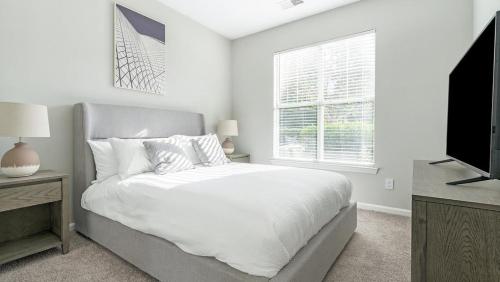 Habitación blanca con cama y TV en Landing Modern Apartment with Amazing Amenities (ID1170X300), en Durham