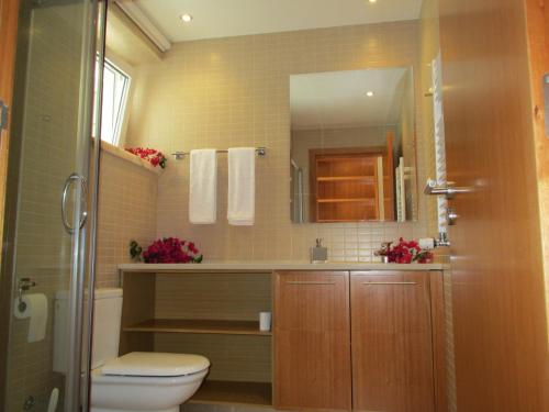 ein Badezimmer mit einem WC, einem Waschbecken und einem Spiegel in der Unterkunft Casa Mirantina in Lagos