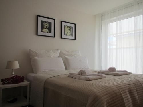 ein Schlafzimmer mit Handtüchern auf einem Bett mit Fenster in der Unterkunft Casa Mirantina in Lagos