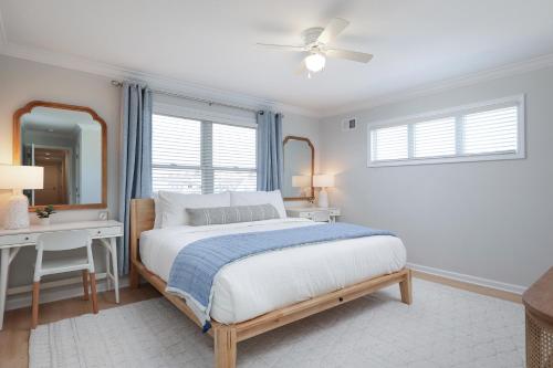 a white bedroom with a bed and a mirror at The Pelican's Perch: New Build in Seaside Heights
