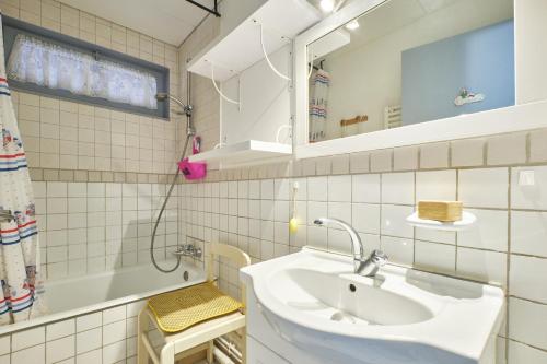 a bathroom with a sink and a mirror and a tub at Le koala in Villard-de-Lans