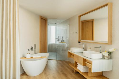 a bathroom with two sinks and a large mirror at Torre Melina, a Gran Meliá Hotel in Barcelona