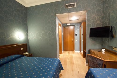 a bedroom with a bed and a desk and a television at Hotel Montecarlo in Rome