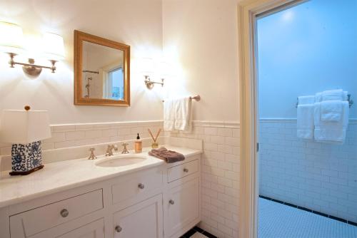 a bathroom with a sink and a mirror and a shower at Ravenna Bed and Breakfast in Natchez