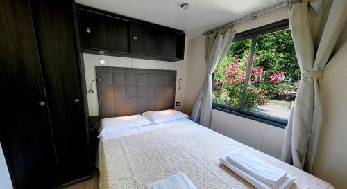 a small bedroom with a bed and a window at Camping Village Tahiti in Lido delle Nazioni