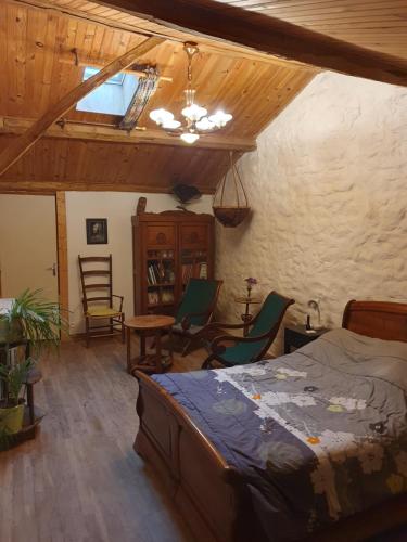 1 dormitorio con 1 cama, mesa y sillas en Chambre d’hôtes de Vauguenige en Saint-Pardoux