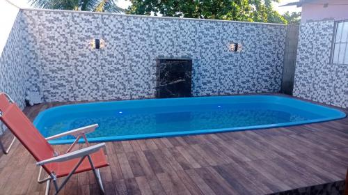 einen Pool auf einer Terrasse mit einem Stuhl in der Unterkunft Casa Porto in Porto Seguro